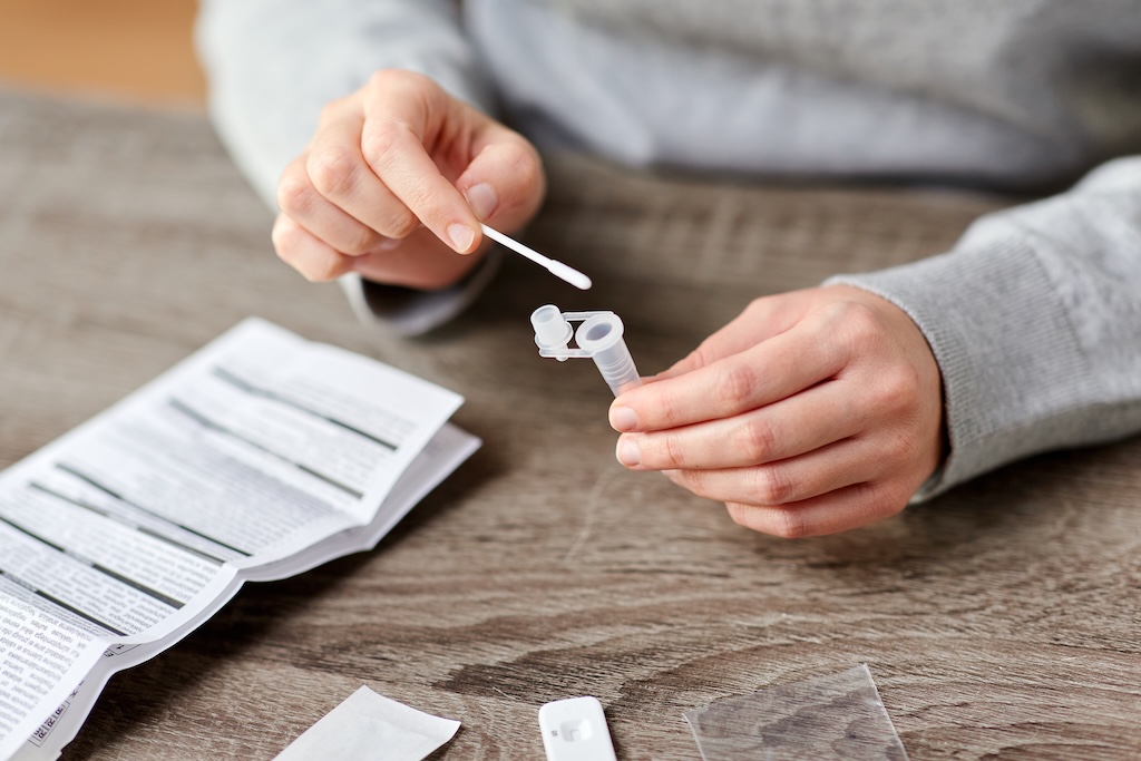 two hands holding a buffer tube and swab
