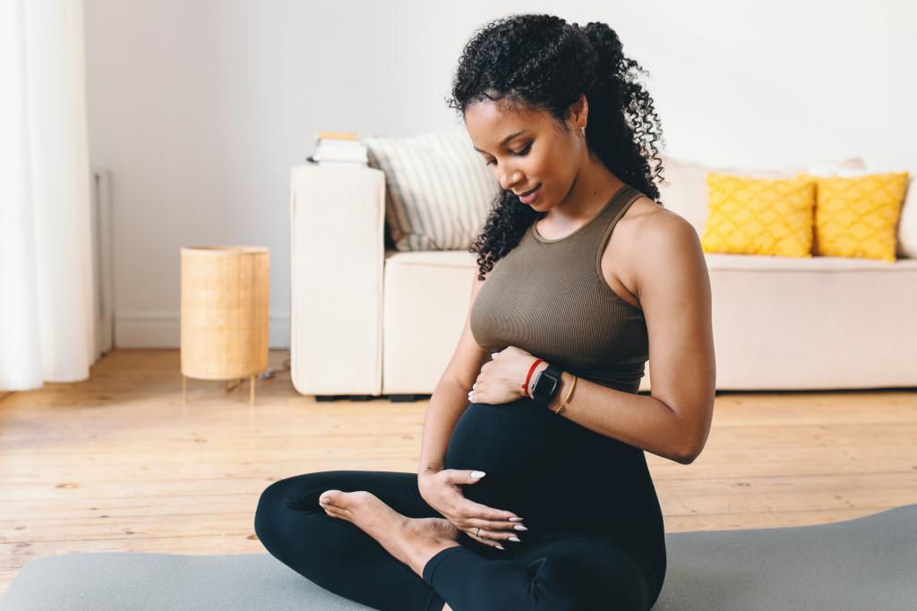 pregnant woman seated with hands on her belly