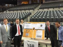 Image of Dalton Nechanicky and others standing beside their Senior Project poster on UPS Supply Chain Solutions
