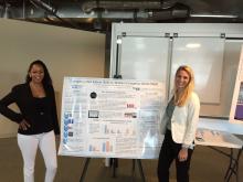 Image of Salimah LaForce and Christina Touzet standing beside their poster on EAS vs. WEA presented at the Disaster Response and Mitigation Forum